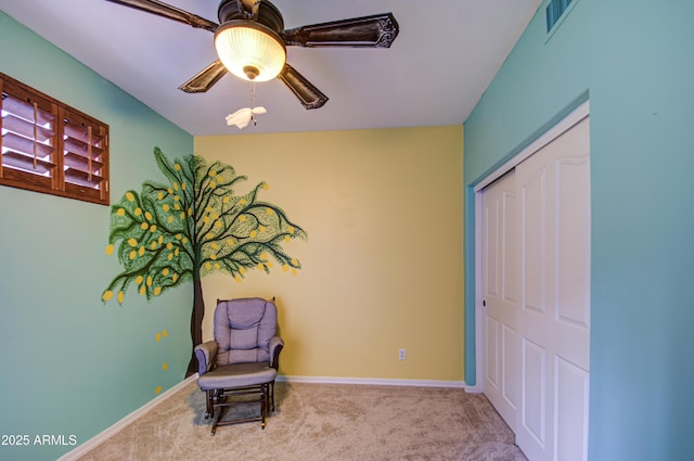 living area with carpet flooring, visible vents, baseboards, and ceiling fan