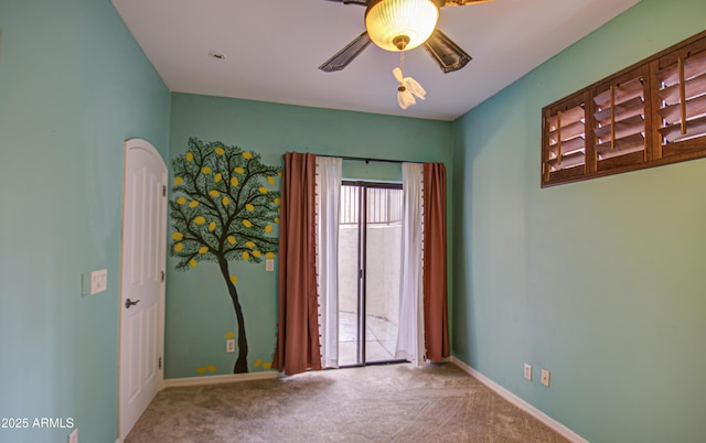 carpeted spare room with baseboards and ceiling fan