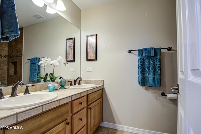 full bath featuring a sink, visible vents, baseboards, and double vanity