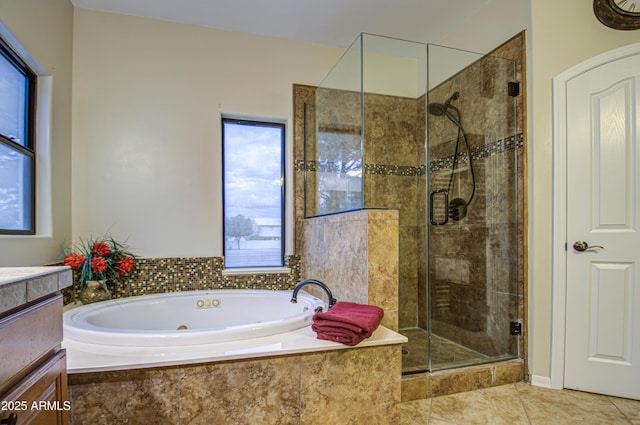 bathroom with tile patterned floors, a stall shower, vanity, and a whirlpool tub