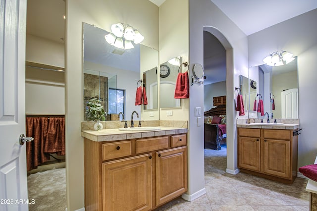 bathroom with a sink, two vanities, ensuite bathroom, and tile patterned floors