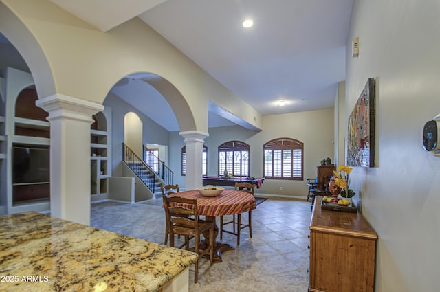 dining area with arched walkways, stairs, baseboards, and decorative columns