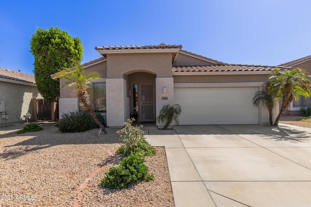 9225 W Clara Ln, Peoria, AZ 85382 - mediterranean / spanish-style house featuring an attached garage, a tiled roof, concrete driveway, and stucco siding