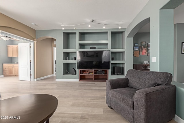 9225 W Clara Ln, Peoria, AZ 85382 - living room with arched walkways, light wood finished floors, baseboards, and built in features