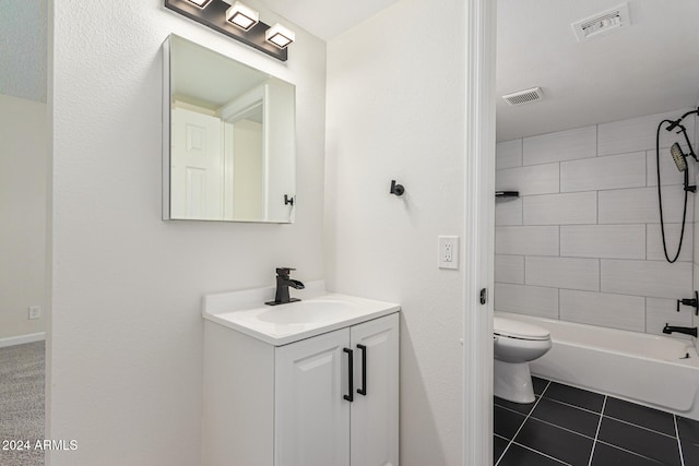 full bathroom with tile patterned floors, tiled shower / bath, vanity, and toilet