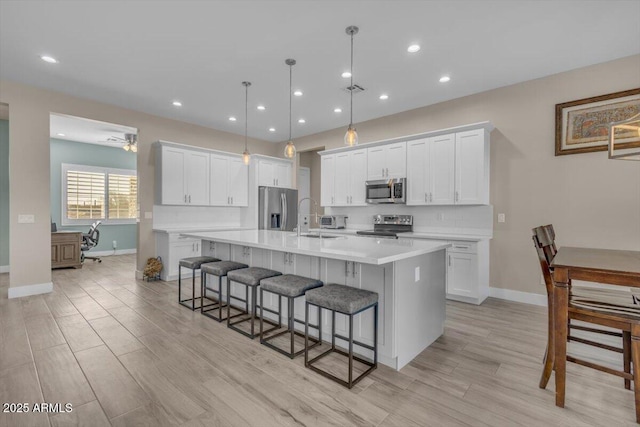 28319 N Marchant Trce, Queen Creek, AZ 85144 - kitchen with a sink, a breakfast bar area, appliances with stainless steel finishes, a large island, and white cabinets