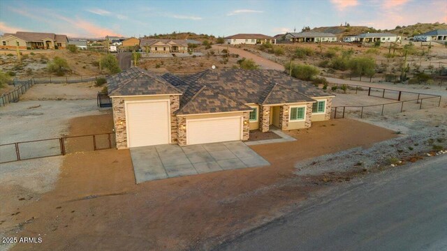 28319 N Marchant Trce, Queen Creek, AZ 85144 - view of front facade featuring stone siding, a garage, fence, and concrete driveway