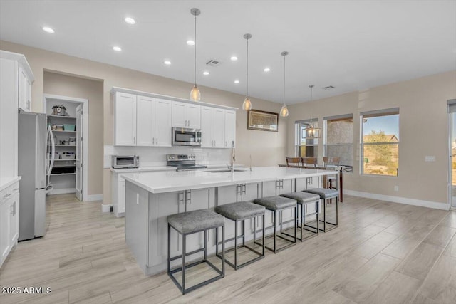28319 N Marchant Trce, Queen Creek, AZ 85144 - kitchen with decorative backsplash, appliances with stainless steel finishes, white cabinetry, a sink, and a large island