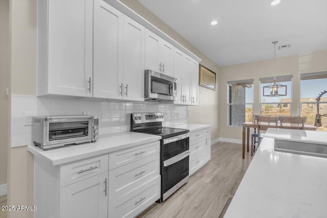 28319 N Marchant Trce, Queen Creek, AZ 85144 - kitchen with light countertops, a toaster, decorative backsplash, white cabinets, and appliances with stainless steel finishes
