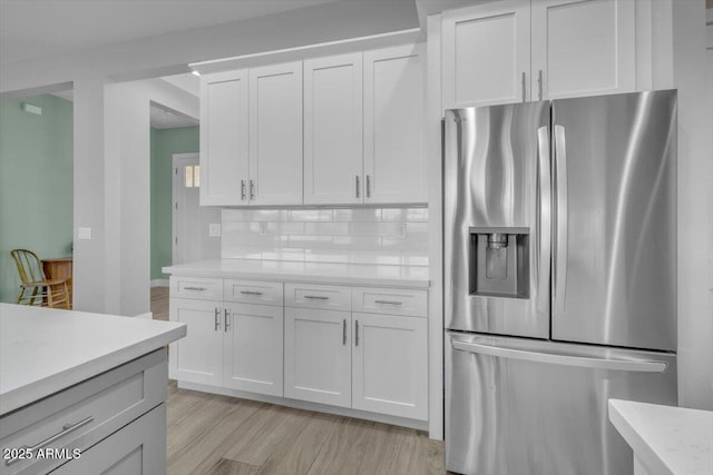 28319 N Marchant Trce, Queen Creek, AZ 85144 - kitchen featuring light countertops, tasteful backsplash, stainless steel refrigerator with ice dispenser, white cabinets, and light wood-style floors