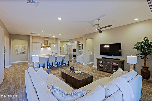 living room featuring ceiling fan and hardwood / wood-style flooring