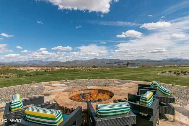 view of patio with a mountain view, a rural view, and an outdoor fire pit