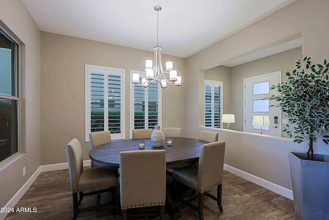 dining space with dark hardwood / wood-style floors and an inviting chandelier