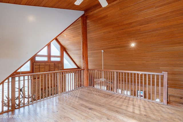 additional living space with ceiling fan, high vaulted ceiling, wooden walls, wood ceiling, and hardwood / wood-style flooring