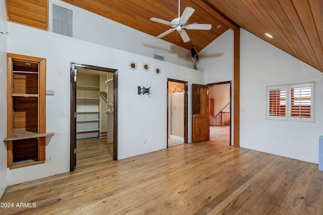 unfurnished bedroom featuring a walk in closet, high vaulted ceiling, wood ceiling, and light wood-type flooring