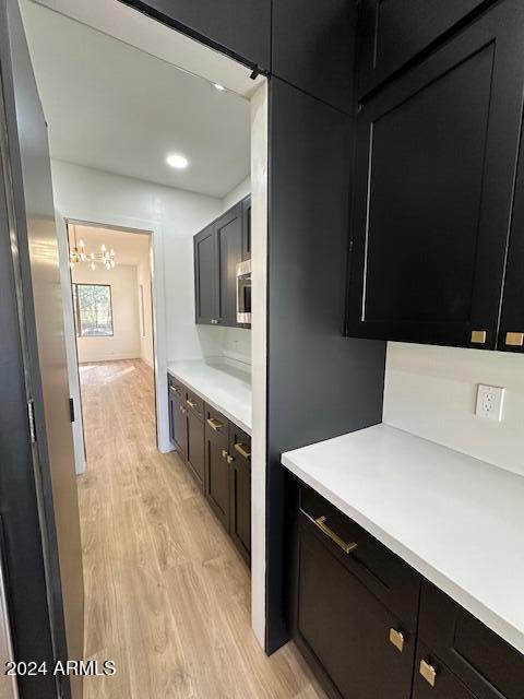 kitchen featuring light wood-type flooring and a notable chandelier