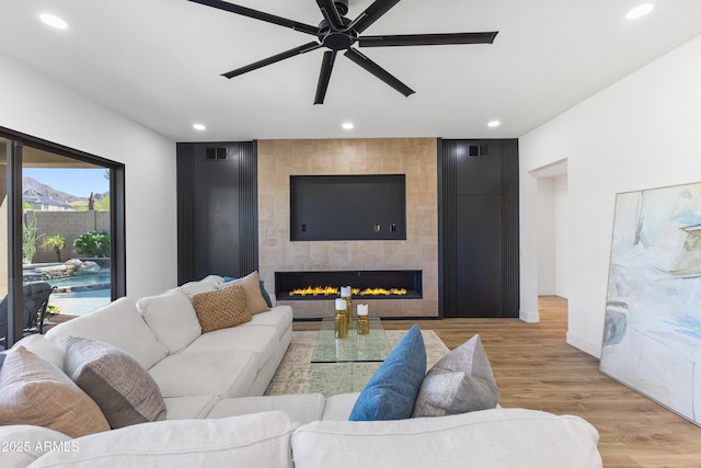 10646 E Butherus Dr, Scottsdale, AZ 85255 - living room featuring recessed lighting, baseboards, ceiling fan, light wood-type flooring, and a large fireplace