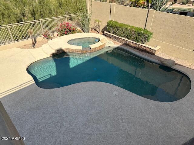 view of swimming pool with an in ground hot tub