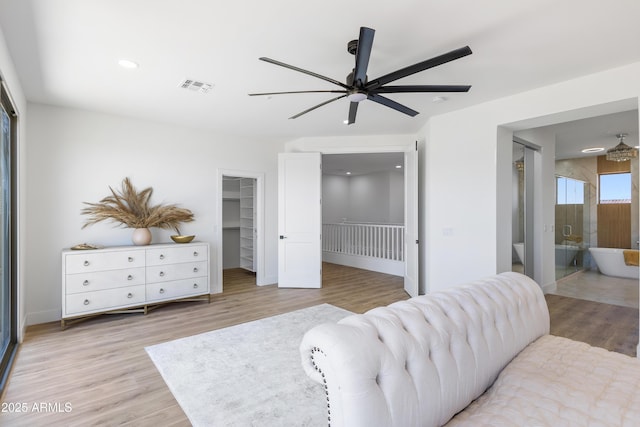 10646 E Butherus Dr, Scottsdale, AZ 85255 - bedroom with a spacious closet, light wood finished floors, a closet, connected bathroom, and recessed lighting