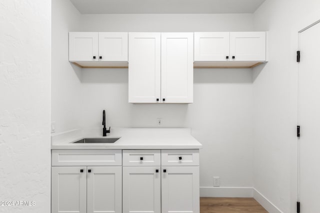 kitchen featuring white cabinetry, sink, and light hardwood / wood-style flooring