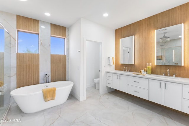 10646 E Butherus Dr, Scottsdale, AZ 85255 - bathroom featuring marble finish flooring, toilet, double vanity, a freestanding tub, and recessed lighting
