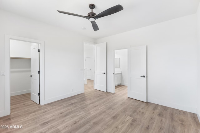 10646 E Butherus Dr, Scottsdale, AZ 85255 - unfurnished bedroom featuring light wood-style floors, a walk in closet, baseboards, and a closet