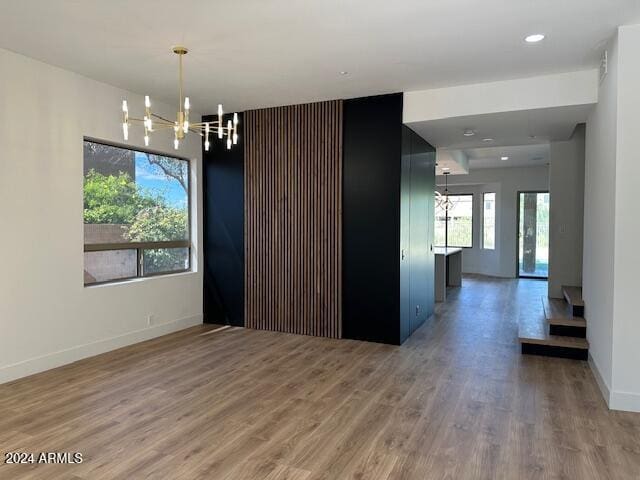 empty room featuring a chandelier and wood-type flooring