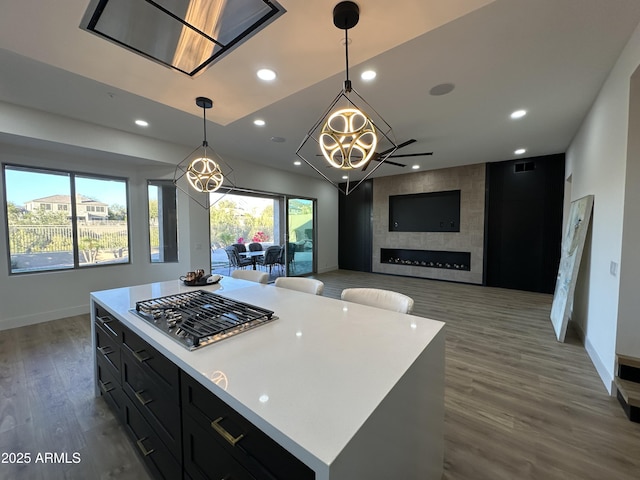 10646 E Butherus Dr, Scottsdale, AZ 85255 - kitchen with stainless steel gas stovetop, dark cabinets, baseboards, light countertops, and recessed lighting