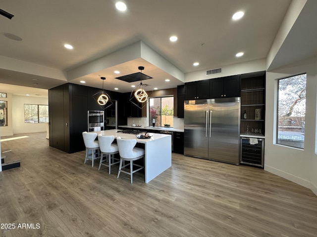 10646 E Butherus Dr, Scottsdale, AZ 85255 - kitchen featuring stainless steel appliances, wine cooler, dark cabinets, light countertops, and a sink
