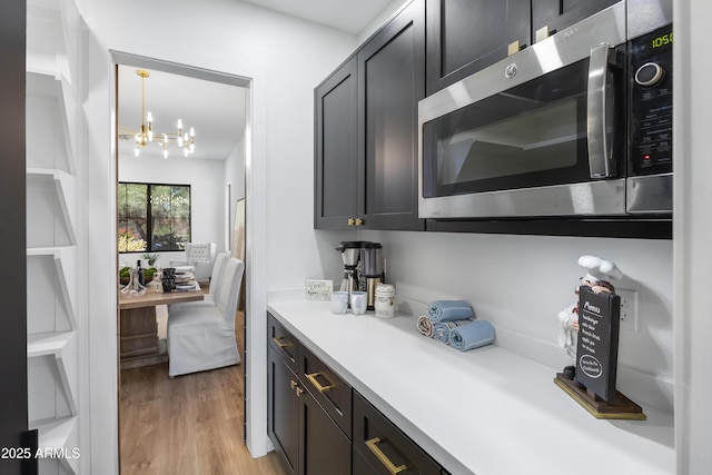 10646 E Butherus Dr, Scottsdale, AZ 85255 - kitchen with stainless steel microwave, a chandelier, light countertops, and light wood-style floors