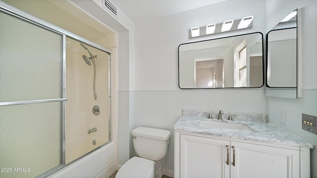 full bathroom featuring vanity, bath / shower combo with glass door, and toilet