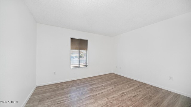 empty room featuring light hardwood / wood-style floors and a textured ceiling