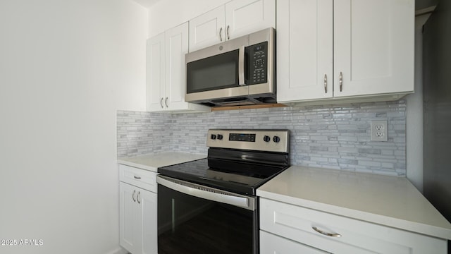 kitchen featuring backsplash, white cabinets, and appliances with stainless steel finishes