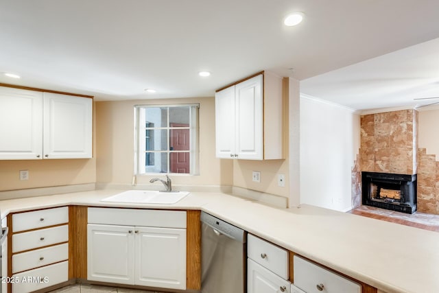 4850 E Desert Cove Ave Unit 240, Scottsdale, AZ 85254 - kitchen with stainless steel dishwasher, ornamental molding, white cabinetry, a tiled fireplace, and a sink