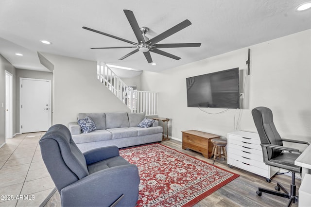 living area with recessed lighting, ceiling fan, wood finished floors, baseboards, and stairs