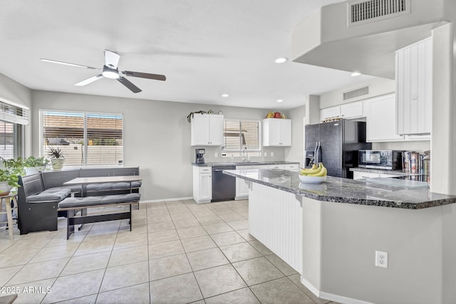 kitchen with a peninsula, visible vents, white cabinetry, dark stone counters, and black appliances