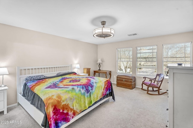 bedroom with baseboards, visible vents, and light colored carpet