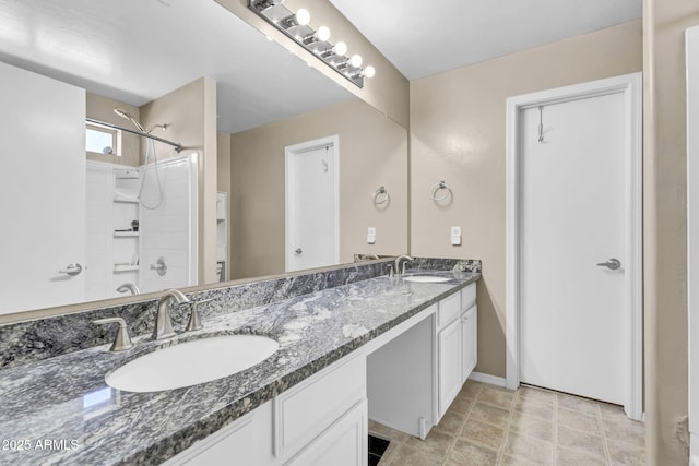 bathroom featuring  shower combination, a sink, baseboards, and double vanity