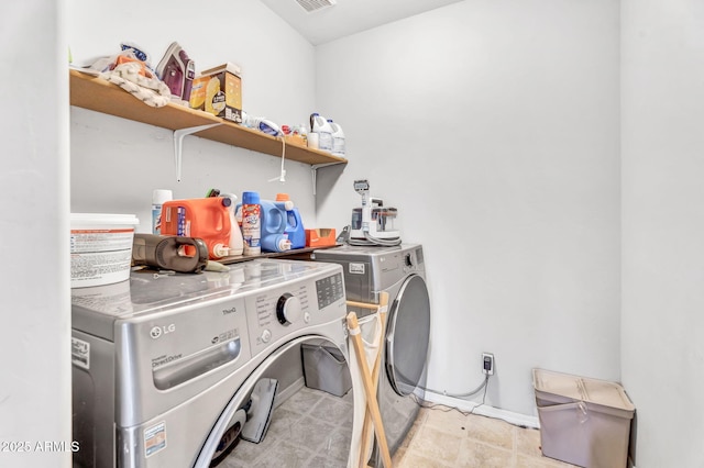 washroom featuring washing machine and dryer, laundry area, visible vents, and baseboards