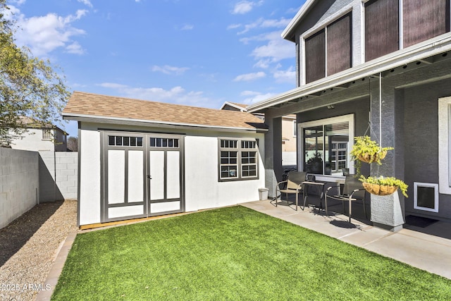 exterior space with an outbuilding, a patio area, and fence