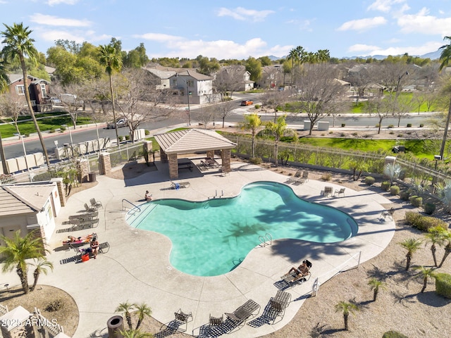 pool featuring a residential view, a patio area, fence, and a gazebo