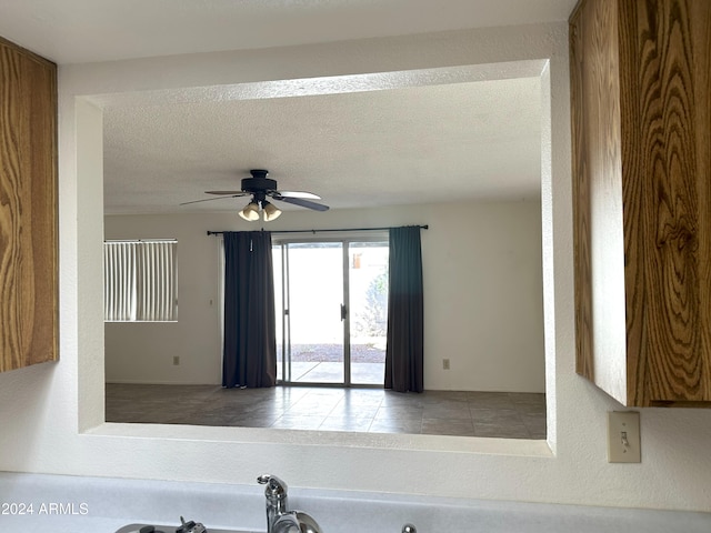 room details featuring ceiling fan and a textured ceiling