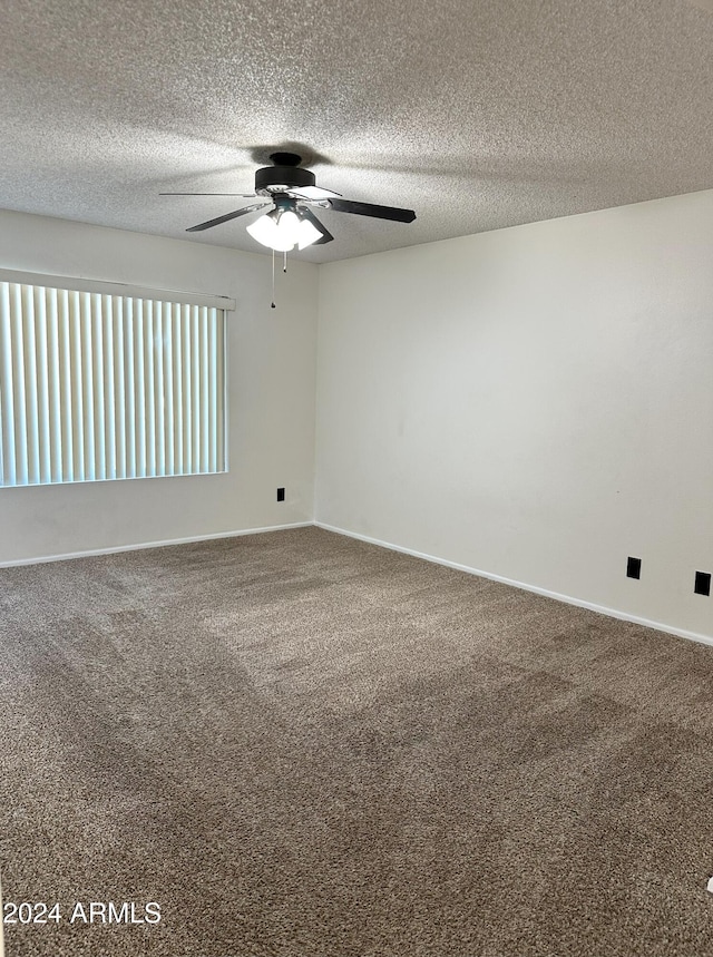 spare room featuring carpet flooring, ceiling fan, and a textured ceiling