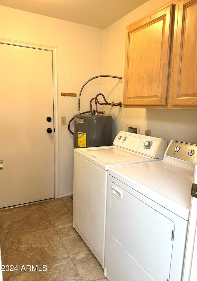 clothes washing area featuring washer and dryer, cabinets, and water heater