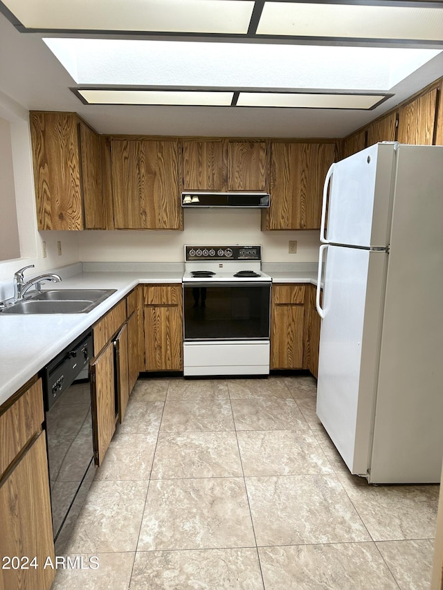 kitchen featuring light tile patterned flooring, white appliances, and sink