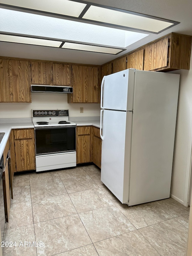 kitchen featuring light tile patterned flooring and white appliances