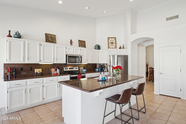 4936 E Villa Rita Dr, Scottsdale, AZ 85254 - kitchen featuring visible vents, arched walkways, dark countertops, stainless steel appliances, and a sink