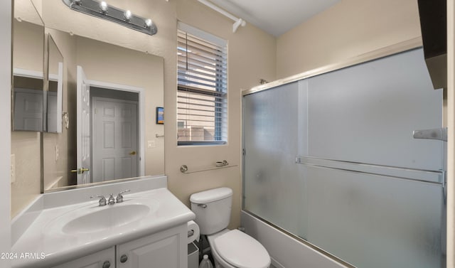 full bathroom with vanity, toilet, and enclosed tub / shower combo