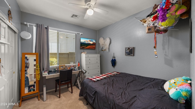 bedroom with a closet, light colored carpet, and ceiling fan