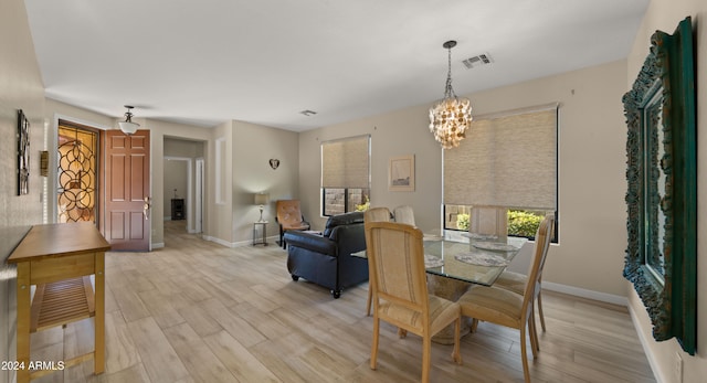 dining room with light hardwood / wood-style flooring and a notable chandelier